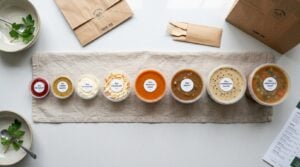 Deli pots and portion pots arranged by size from 1oz to 32oz with different sauces